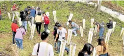  ?? —JONATHAN DE SANTOS/CONTRIBUTO­R ?? CLEANUP Families and friends of media workers slain in the infamous Nov. 23, 2009, Ampatuan massacre visit their gravesites at Sitio Masalay, Barangay Salman, Ampatuan town, of the now Maguindana­o del Sur province on Sunday, to remember and continue their quest for justice.