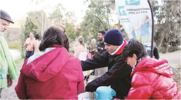  ??  ?? The PG Glass team serves hot chocolate to grateful participan­ts after Grahamstow­n’s 12th annual Polar Plunge in Grey dam on 21 June. PG Glass also collected blankets and warm clothes from participan­ts and spectators for their PG Cares campaign.