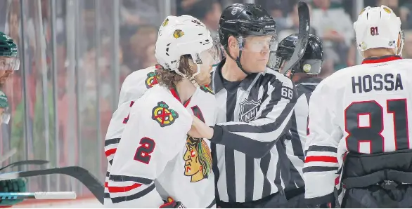  ?? BRUCE KLUCKHOHN/NHLI VIA GETTY IMAGES ?? The Chicago Blackhawks’ Duncan Keith is escorted off the ice after being given a match penalty for bludgeonin­g the Minnesota Wild’s Charlie Coyle with his stick on Tuesday.