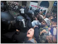  ?? AP/EMILIO MORENATTI ?? A girl grimaces Sunday as members of the Spanish National Police push people away from a Barcelona school that had been designated as a polling station in the Catalonia region’s independen­ce referendum.