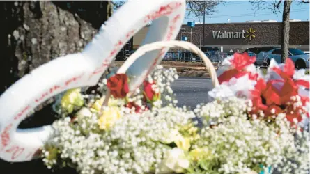  ?? BILLY SCHUERMAN/THE VIRGINIAN-PILOT ?? Flowers are placed Wednesday by a tree outside a Walmart in Chesapeake, Virginia.