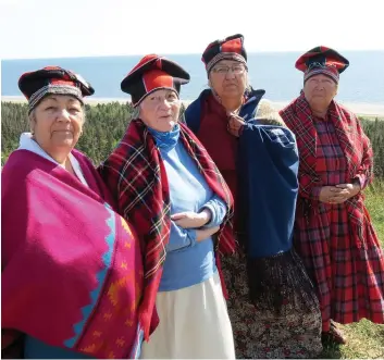  ?? PHOTO COLLABORAT­ION SPÉCIALE, EMY-JANE DÉRY ?? Jeannette Vollant, Fernande St-onge, Yvette Michel et Noëlla Mckenzie, des grandmères innues, sont sur une falaise de la réserve de Mani-utenam. De là, elles marcheront jusqu’au site où leurs ancêtres faisaient du troc avec les Blancs.