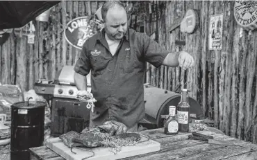  ?? Photos by Carlos Javier Sanchez / Contributo­r ?? Chuck Blount tests a Pit Barrel Cooker device, finding it gives a refreshing charcoal flavor to smoked meats.