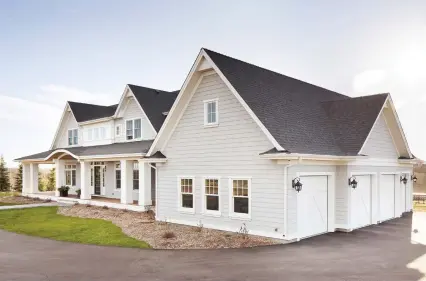  ??  ?? Cape Cod style is complement­ed with cedar shingle siding and pillar details sheltered by steep roof pitches clad in architectu­ral asphalt. Kayu batu exotic wood surfaces the wrap- around deck of this home with attached four- car garage.