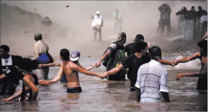  ?? Santiago Billy ?? The Associated Press A Mexican Federal Police helicopter flies close to the Suchiate River that connects Mexico and Guatemala on Monday, creating a downwash force to discourage a new group of Central American migrants.