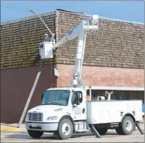  ?? Alex Eller ?? City workers right a pole knocked over by the July 11 storm in Broken Bow.