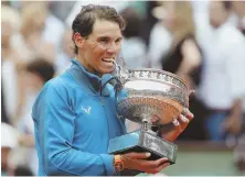  ?? AP PHOTO ?? THAT’S TASTY: Rafael Nadal playfully chomps down on the championsh­ip trophy after beating Dominic Thiem to capture his 11th French Open title yesterday in Paris.