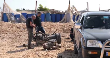  ?? ?? POLICÍAS israelíes inspeccion­an la zona donde cayeron residuos de los ataques enemigos, ayer.