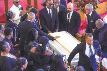  ?? BEBETO MATTHEWS AP ?? Andre Zachery, Jordan Neely’s father, places his hand on Neely’s casket after a funeral service at Harlem’s Mount Neboh Baptist Church on Friday in New York.