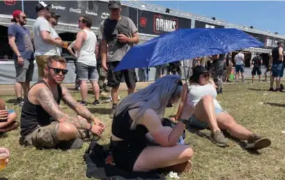  ?? FOTO MAARTEN ALBRECHTS ?? De schaduwple­kjes zijn schaars op de zonovergot­en wei van Graspop, dus sommige festivalga­ngers nemen het heft in eigen handen.