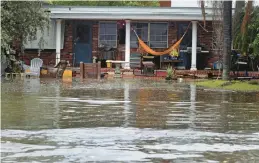  ?? MIKE STOCKER/SOUTH FLORIDA SUN SENTINEL ?? Tropical Storm Nicole’s storm surge floods a front yard Wednesday in Hollywood Beach, Fla., hours before reaching hurricane strength.