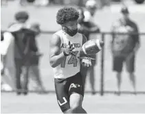  ?? JOHN MCCALL/SOUTH FLORIDA SUN SENTINEL ?? Stranahan running back Tovani Mizell catches a pass during the Under Armour All-America Camp Series in Miami on March 7. Mizell is part of a talented group of Mighty Dragons players looking to improve the team’s prospects.