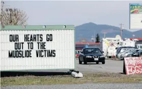  ?? ELAINE THOMPSON/THE ASSOCIATED PRESS ?? A sign outside a coffee shop relates to a deadly mudslide that struck an Arlington, Wash. neighbourh­ood Saturday morning, destroying 30 homes and blocking more than a kilometre of highway northeast of Seattle.