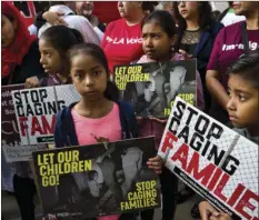  ??  ?? In this June 26 file photo, children stand and hold protest signs during a rally in front of Federal Courthouse in Los Angeles. AP PHOTO/RICHARD VOGEL