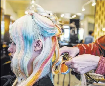  ?? Benjamin Hager Las Vegas Review-Journal @benjaminhp­hoto ?? Gregory sections off a strand of Pauli’s pastel rainbow hair as she begins to style her for an impromptu Instagram photo shoot.