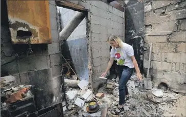  ?? Sergei Chuzavkov AFP/Getty Images ?? A WOMAN cooks in the ruins of her home near Chernihiv in northeast Ukraine. Chernihiv, about 55 miles from the Russian border, endured a 38-day siege including strikes believed to be from Russian cruise missiles.