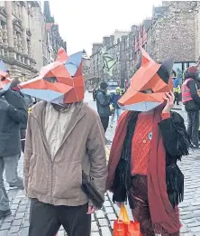  ??  ?? Extinction Rebellion Scotland protesters wearing fox masks in Edinburgh.