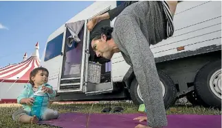  ?? PHOTO: JOSEPH JOHNSON/STUFF ?? Cirque Grande performer Edward Clendon stretches on a mat in front of his caravan that he lives in with his partner and daughter.