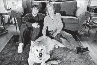  ?? JOHN J. KIM/CHICAGO TRIBUNE ?? Cynthia Beebe, a former special agent with the Bureau of Alcohol, Tobacco, Firearms and Explosives, with her son, Sam, and their dog in their Evanston home. Beebe dedicated her book, “Boots in the Ashes,” to Sam.