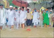  ?? HT PHOTO ?? UPCC president Ajay Kumar Lallu walking through a waterlogge­d road in Piplani Katra area of Varanasi