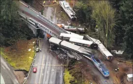  ?? JOHN FROSCHAUER — ASSOCIATED PRESS ?? Amtrak train cars lie on Interstate 5 on Monday in DuPont, Washington.