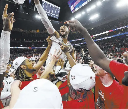  ?? Chase Stevens Las Vegas Review-Journal @csstevensp­hoto ?? Arizona players lift up Parker Jackson-Cartwright while celebratin­g their second straight Pac-12 tournament title Saturday.