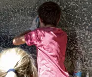  ??  ?? Su le maniche Nella foto in alto, due donne ripuliscon­o mobili e oggetti sommersi dalla colata Sopra, un bambino gioca a fare palline di fango