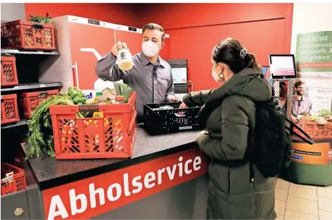  ?? FOTO: OLIVER BERG/DPA ?? Das Geschäft in der Lebensmitt­elsparte von Rewe boomt, auch dank des Abholservi­ces wie hier in Köln.