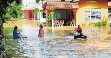  ?? PIC BY MUHAMMAD ZUHAIRI ZUBER ?? Children playing in the floodwater after their houses in Kampung Tanjung Minyak,
Melaka, were inundated yesterday.