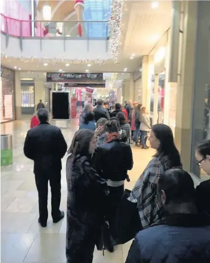  ??  ?? Queues of Christmas shoppers outside the Pandora shop in St David’s shopping centre, Cardiff