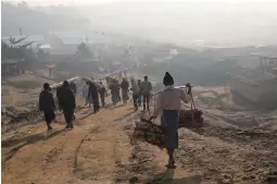  ?? (Mohammad Ponir Hossain/Reuters) ?? ROHINGYA REFUGEES walk at the Jamtoli camp in Cox’s Bazar, Bangladesh, earlier this week.