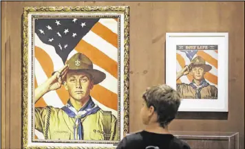  ?? RICK BOWMER / AP 2013 ?? A boy looks over a Boy Scout-themed Norman Rockwell exhibition at the Church History Museum in Salt Lake City in 2013. The Mormon church, the largest sponsor of Boy Scout troops in the U.S., is pulling older teenagers from the organizati­on.