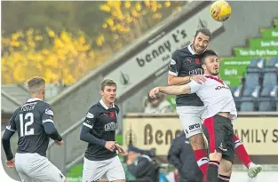  ??  ?? Mark Durnan wins an aerial challenge with Paul Mckay