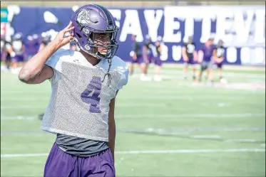  ?? NWA Democrat-Gazette/J.T. WAMPLER ?? Fayettevil­le’s Kris Mulinga buckles his chinstrap during practice Wednesday at Harmon Field in Fayettevil­le. The senior receiver has emerged as one of the Purple’Dogs’ top targets because of his big-play ability.