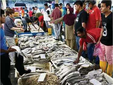  ?? — Reuters ?? Strong economy: A file picture showing customers choosing seafood at a wet market in Klang. The GDP for the fourth quarter of 2017 is estimated at 6% for Malaysia.