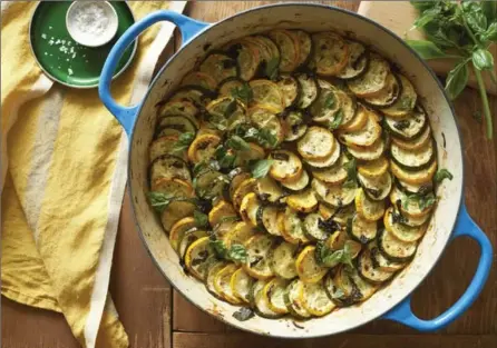  ?? MELINA HAMMER, NYT ?? Summer vegetable gratin with squash and zucchini slices atop a base of onion and bell pepper, which can optionally be topped with a layer of tomatoes, cheese and bread crumbs.