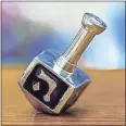  ?? Contribute­d ?? A common form of entertainm­ent during Chanukah is playing with a dreidel, a four-sided top with Hebrew letters on each side.