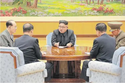  ?? AFP ?? Explicacio­nes. Kim Jong-un habla con miembros de su gobierno. La foto fue difundida por Pyongyang.