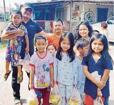  ??  ?? FRANCIS merakamkan kenangan bersama kanak-kanak pelbagai bangsa di kawasan setinggan.