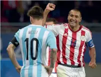  ?? — AFP ?? Paraguay’s Paulo Da Silva celebrates next to Argentina’s Lionel Messi after their team fought back to earn a point.