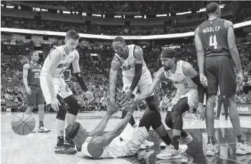  ?? D.A. VARELA dvarela@miamiheral­d.com ?? From left, the Heat’s Tyler Herro, Bam Adebayo and Gabe VIncent help Jimmy Butler off the floor in a game against the Cavaliers on March 8. Miami is above .500 despite being outscored by 0.7 points per 100 possession­s this season.