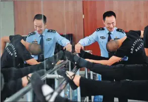  ?? ZHANG LEI / FOR CHINA DAILY ?? A police officer explains dance moves to an offender in Sichuan province.