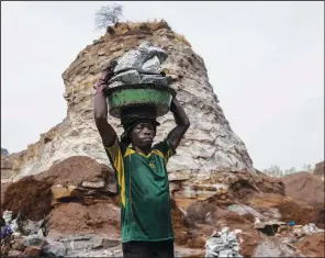  ?? ?? A man carries rocks at the mine.