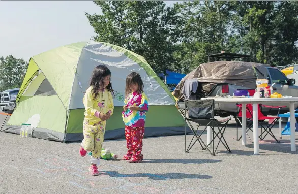  ?? PHOTOS: RICHARD LAM ?? Taya Shaw, left, and her sister Domica try to make the best of living at the College of New Caledonia parking lot in Prince George after their family fled Williams Lake.