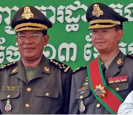  ?? AFP ?? ALL IN THE FAMILY This photo taken on Oct. 13, 2009, shows Cambodian Prime Minister Hun Sen (left) posing with his son, Hun Manet, during a ceremony at a military base in Phnom Penh.