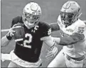  ?? MADDIE MEYER/GETTY ?? Notre Dame quarterbac­k Ian Book tries to outrun Boston College’s Isaiah McDuffie on Saturday in Chestnut Hill, Mass.