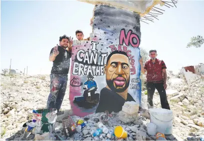  ?? Picture: AFP ?? GIVE PEACE A CHANCE. Syrian artists Aziz Asmar and Anis Hamdoun finish a mural depicting George Floyd, in the town of Binnish in Syria’s northweste­rn Idlib province.