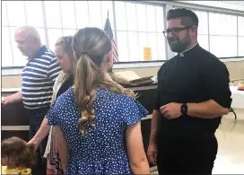  ?? Photo by Becky Polaski ?? Fr. Ross Miceli, right, is shown interactin­g with attendees during a farewell reception that was held at the St. Boniface Parish social hall in June. Today begins Miceli’s new assignment as pastor of St. Jude the Apostle Parish in Erie.