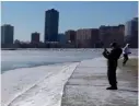  ?? NAM Y. HUH/AP ?? A woman bundled in winter gear takes photos of Lake Michigan at Montrose Beach on Tuesday.