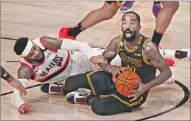  ?? Kim Klement Getty Images ?? THE LAKERS’ JR Smith looks to pass as he battles the Trail Blazers’ Carmelo Anthony during Game 4 on Monday night. The Lakers cruised to a 135-115 victory.